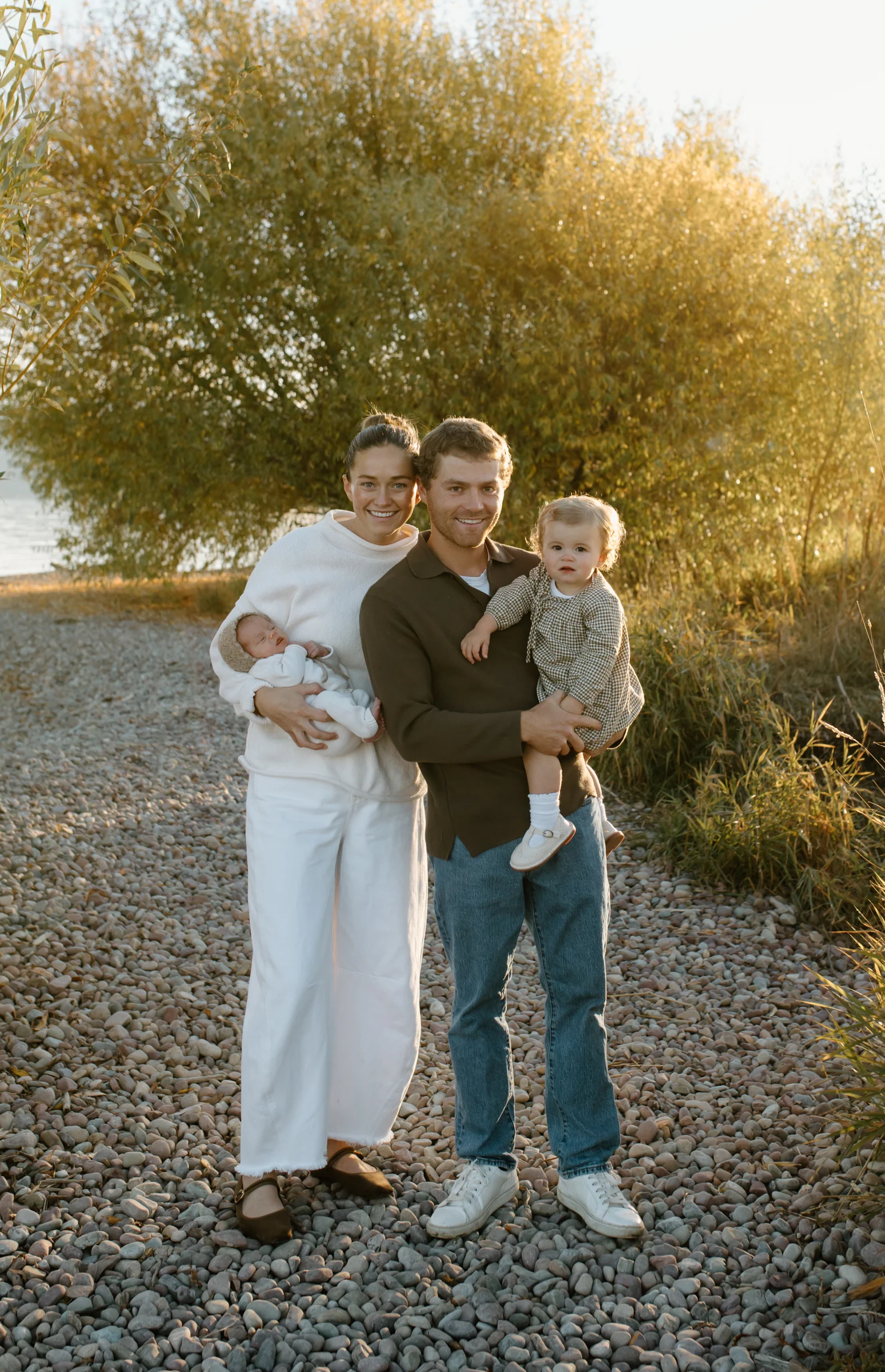 A family standing together on grass in warm light