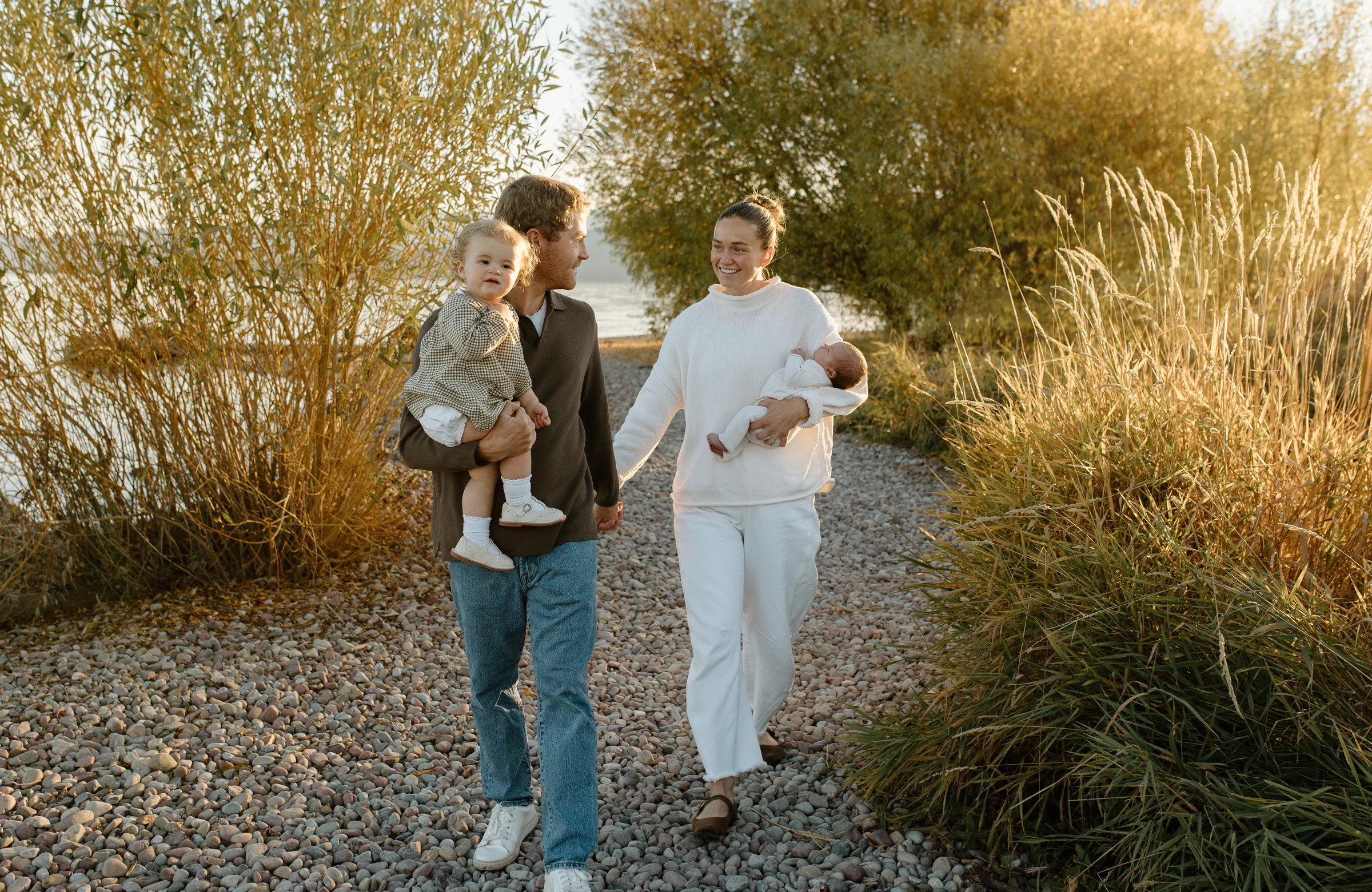 A parent walking outdoors with children