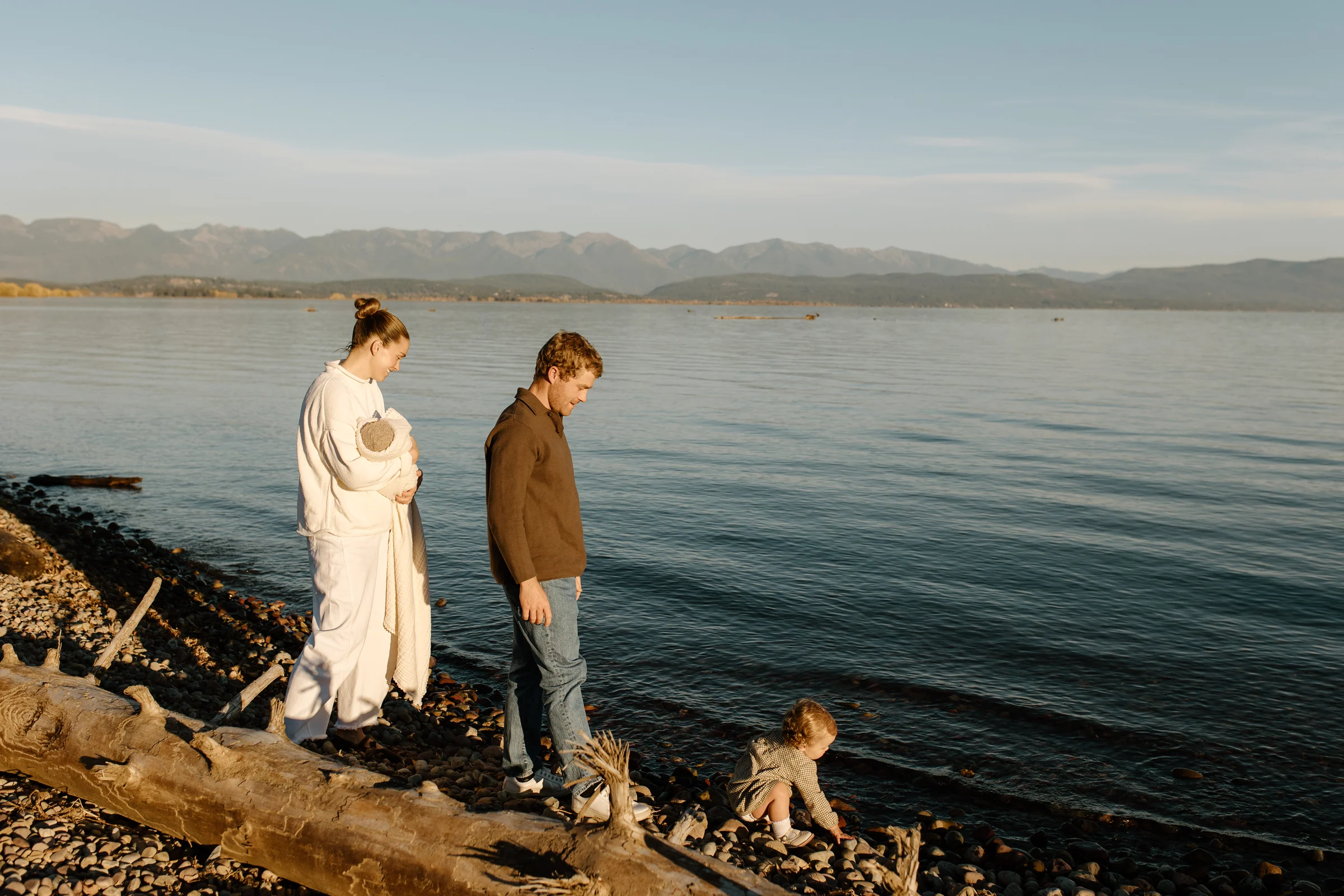 A couple standing together at the edge of a mountain lake