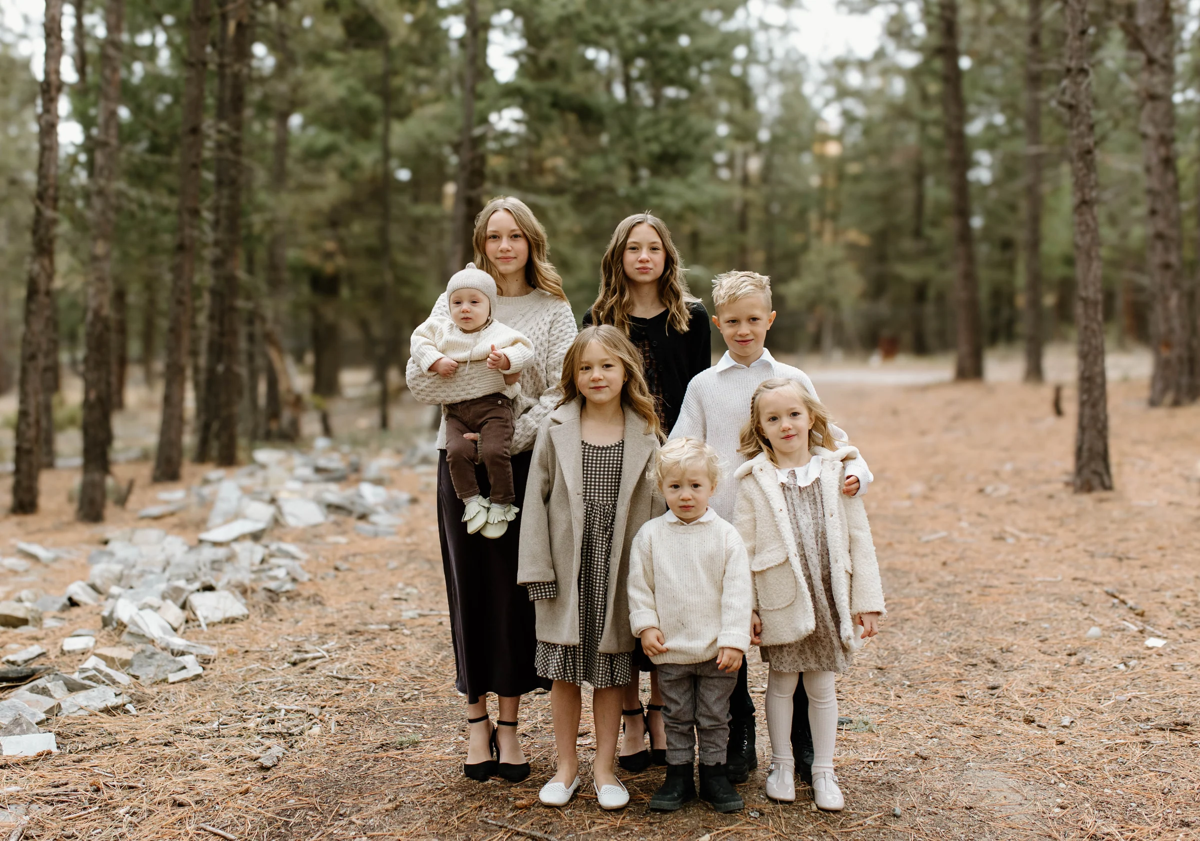 A family standing together on a forest path